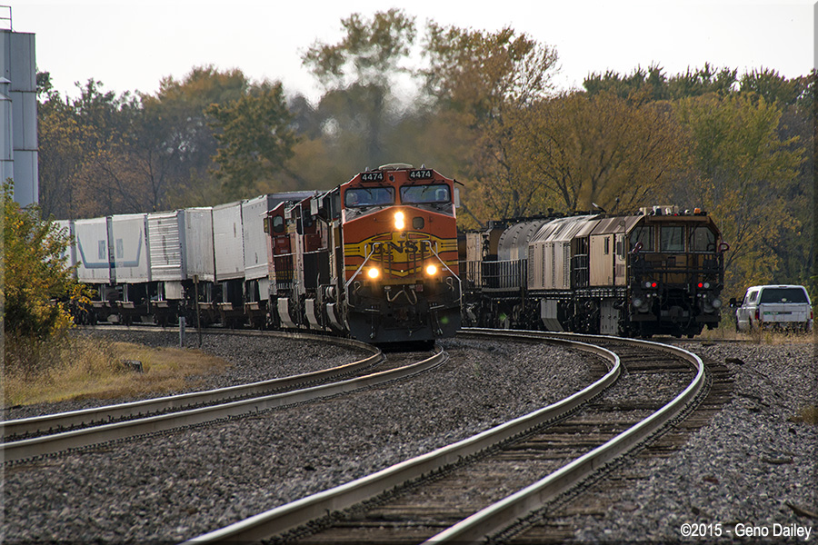 This eastbound BNSF van train passes by the Loram Rail Grinder near the