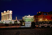 With the Las Vegas Strip glowing brightly behind, a BNSF run-through train waits patiently along the UP's Cima Sub.  (225K)
