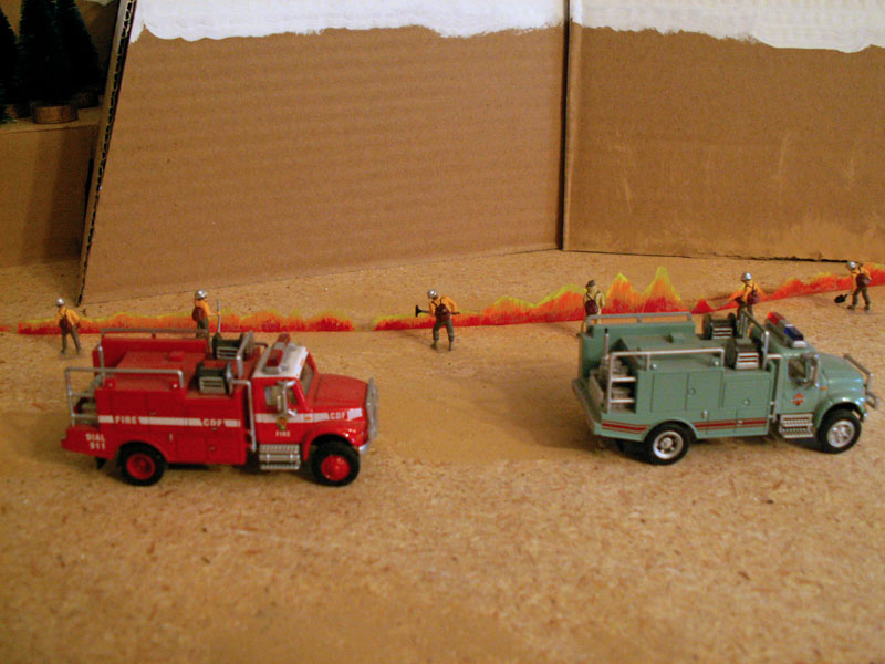 Two brush fire trucks from the California Department of Forestry fight a