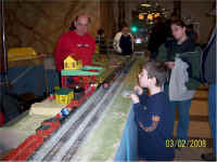 Another young guest takes a turn at the log loader while Don Confarotta watches.