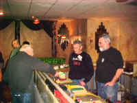 Chuck Smith, George Cole and Dave Daniel look at the American Flyer sawmill, our only operating accessory that worked for the entire show..