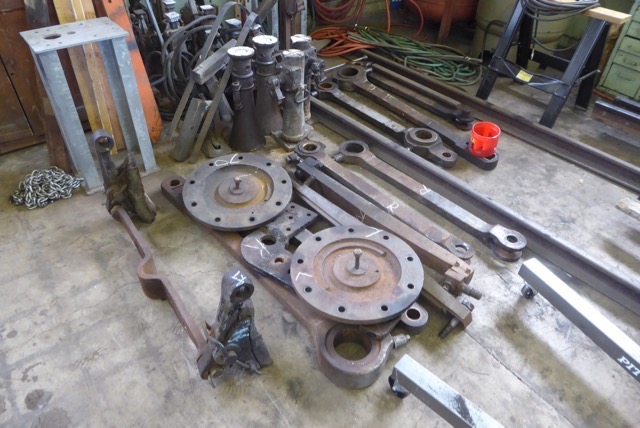 Rods and other parts stacked to the side of the shop behind the tender.