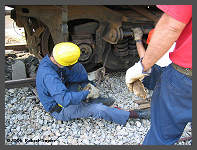 (c)2006 Robert Snyder - Al O. uses some muscle to coax the wheel bearing out of its pedestal. (10K) - CLICK to Enlarge (60K)